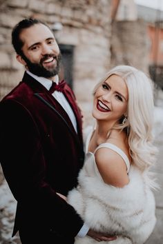 a man and woman dressed in formal wear standing next to each other on the street