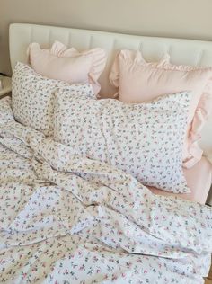 an unmade bed with pink and white sheets