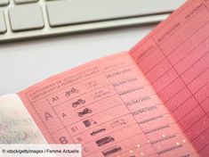 a close up of a person's hand holding a pink paper