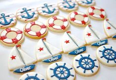 decorated cookies with sailboats, ships and stars on them sitting on a white tablecloth