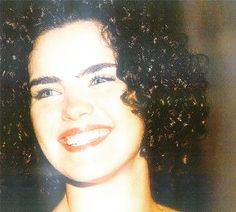 a woman with curly hair smiling at the camera