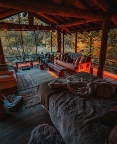 a bed sitting in the middle of a bedroom next to a wooden floor covered in blankets