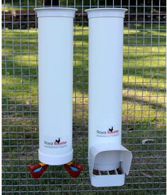 two white water tanks sitting next to each other on top of a grass covered field