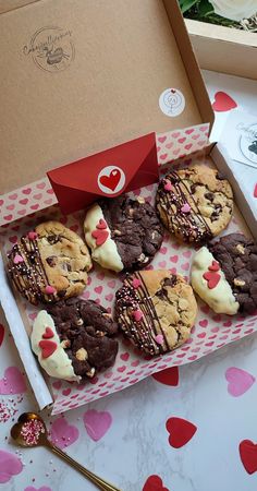 chocolate chip cookies with white frosting and sprinkles in a valentine's box