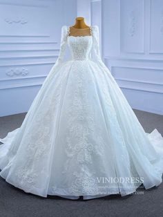 a white wedding dress with long sleeves and laces on the bouncy skirt