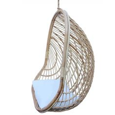 the hanging chair is made out of wicker and has a white cushion on it