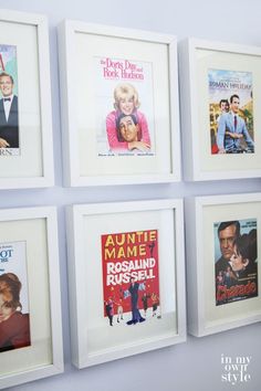 four framed movie posters hang on the wall in front of blue walls with white frames