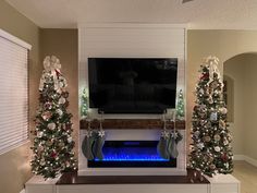 a living room decorated for christmas with fireplace and tv