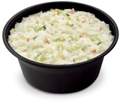 a casserole dish filled with coleslaw and carrots in a black bowl