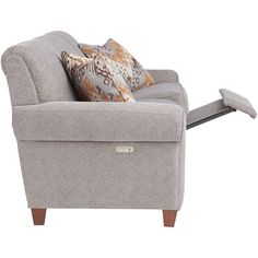 a gray chair with two pillows on it and a remote control in the armrests