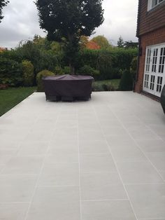 an outdoor patio with a grill cover on it