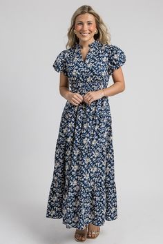 This navy maxi is covered in a pretty off white and chartreuse floral print. The sweet ruffle trimmed collar gives way to a notch neckline, and the cinched elastic waistband flows into a tiered maxi skirt. Short balloon sleeves complete the look. Dress it up with gold earrings and heels for a fall wedding, or simply style it with sandals or booties and hoops!  Pull-on fit Sleeves are lined Cinched elastic waist  Elastic sleeve... Casual Floral Print Tiered Maxi Dress, Casual Floral Print Maxi Dress With Tiered Skirt, Off Shoulder Jacket, Tiered Maxi Skirt, Skirt Short, Blue Door, Navy Floral, Floral Maxi, Black Maxi Dress