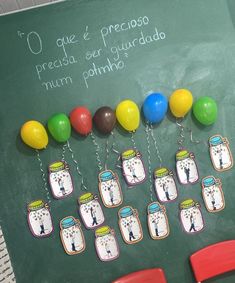 a chalk board with balloons and magnets attached to it's sides in spanish