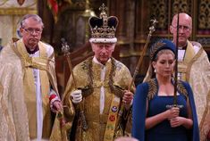 two men and one woman are standing in front of other people wearing priest's robes