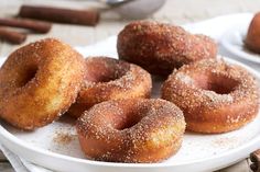 cinnamon sugar donuts on a plate with cinnamon sticks