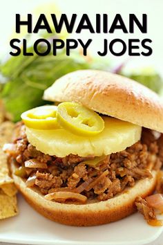 a pulled pork sandwich on a plate with potato chips and lettuce next to it