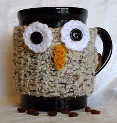 a crocheted coffee cup holder with an owl's face on it, surrounded by coffee beans