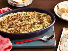 a casserole dish with bread and crackers on the side