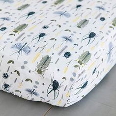 a close up of a sheet on the floor with bugs and plants all over it