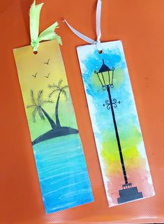 two bookmarks with watercolors and palm trees on them, one has a lamp post