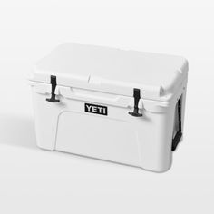 a white yeti cooler sitting on top of a white table next to a black handle