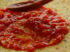 a wooden spoon sitting on top of a tortilla covered in marinara sauce