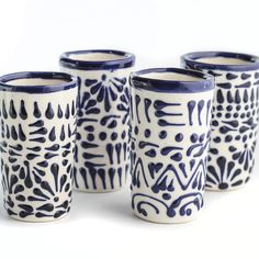 four blue and white cups with designs on them