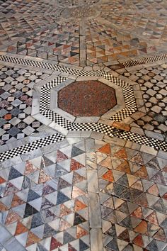 the floor is made up of many different colored tiles and has a circular design on it