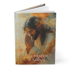 a book with an image of jesus holding his hands together and the words, my prayer journal