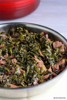 a metal pan filled with meat and greens