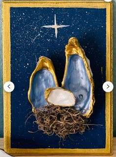 an ornament made to look like two blue oysters with gold trimming