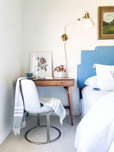 a bed room with a neatly made bed next to a desk and chair on top of it