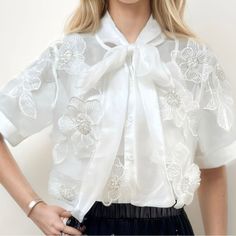 Color: White Description: Sheer Blouse Featuring Floral Embroidery Bow Neckline Concealed Button Front Short Sleeves Floral Embroidery Loose Fit Fabric See Through Embroidery Bow, White Peplum Tops, Sheer Tank Top, Womens Denim Shirt, Long Sleeve Denim Shirt, Eyelet Top, Embroidered Tunic, Dress Gift, Sheer Blouse