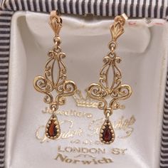 The gemstones in the jewellery are all natural stones. We do not sell jewellery containing manmade, synthetic or laboratory grown stones. This stunning pair of Victorian design ornate vintage drop earrings has been beautifully crafted in 9 carat yellow gold, each earring having a teardrop/pear cut garnet bead set hanging from the scrolled design. A perfect anniversary or birthday gift. Hallmark - The earrings do not have any hallmarks but have been tested and present as 9ct gold. Weight - 1.6g ( Designer Earrings Gold, Victorian Gold Jewelry, Victorian Gold Earrings, October Jewelry, Ornate Jewelry, Victorian Jewellery, Vintage Gold Earrings, Vintage Drop Earrings, Victorian Earrings