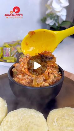 a bowl filled with food sitting on top of a metal plate next to some crackers