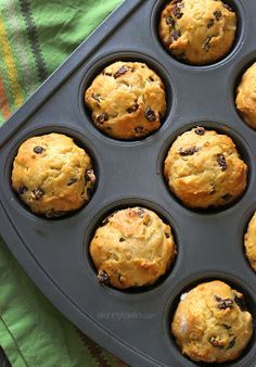 muffins in a pan with raisins on top