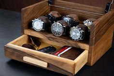 a wooden box with several watches and other items in it