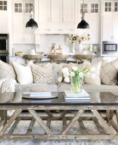 a living room filled with lots of furniture and flowers on top of a coffee table