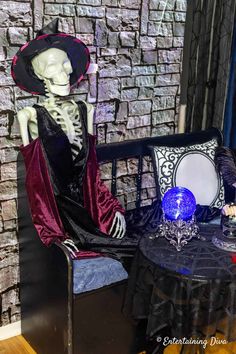 a skeleton sitting on top of a chair next to a table with a blue vase