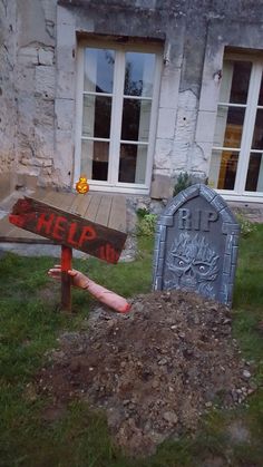 a pile of dirt sitting in front of a house next to a sign that says help