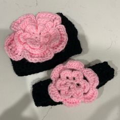 two crocheted pink and black flower hats