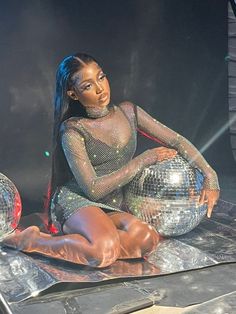 a woman sitting on top of a metal ball