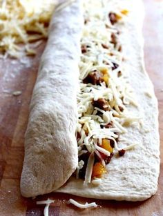 a tortilla with cheese and other toppings sitting on a cutting board