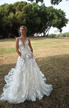 a woman in a wedding dress standing on the grass