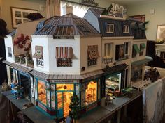 a doll house with many windows and decorations on the top floor in front of it