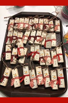 snowmen made out of marshmallows tied to twine on a tray