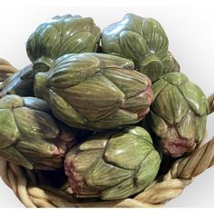 a basket filled with lots of green artichokes