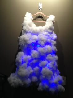 a dress made out of clouds hanging on a wall