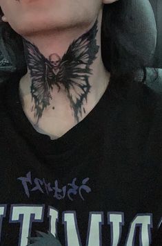 a man with tattoos on his neck and chest is sitting in a car wearing a black shirt