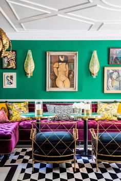 a living room filled with furniture and pictures on the wall above it's colorful couches